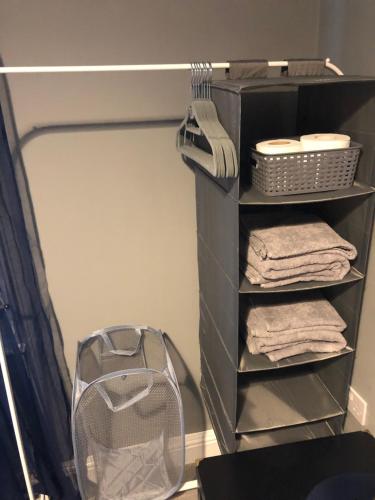 a shelf with towels and a fan in a bathroom at 3. Stylish Private Double Room Near Manchester City Centre in Manchester