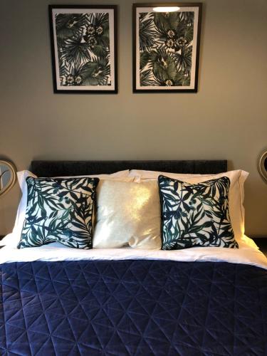 a bed with two pillows and two pictures on the wall at 3. Stylish Private Double Room Near Manchester City Centre in Manchester