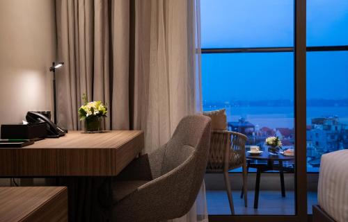 a hotel room with a desk and a window at Oakwood Residence Hanoi in Hanoi