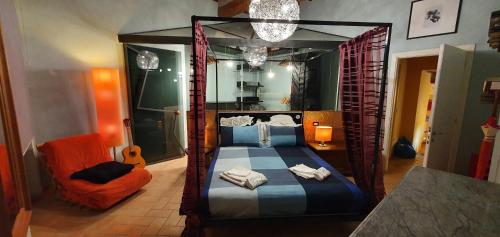 a bedroom with a canopy bed and a chair at Maison Mavù in the center with wifi fiber, 12 minutes on foot from the Umbria Jazz arena and 2 minutes from the free concerts in the square in Perugia
