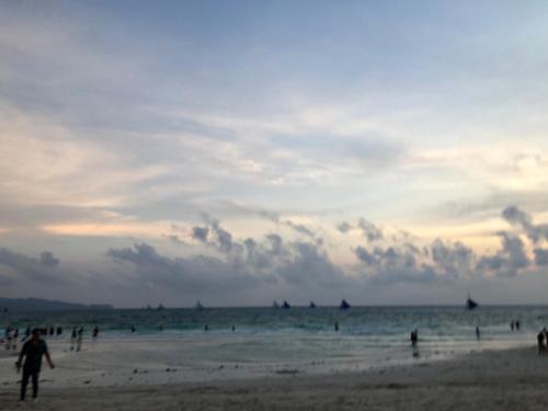 a group of people on the beach at sunset at San Remo Oasis SRP Cebu in Cebu City