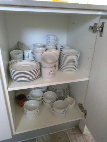 a cupboard filled with white dishes and plates at Casa Rural Txokoetxe in Mungia