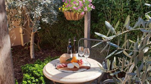a table with wine glasses and a basket of flowers at Fechner Place Barossa, 1 Bed, Wine & Platter in Tanunda
