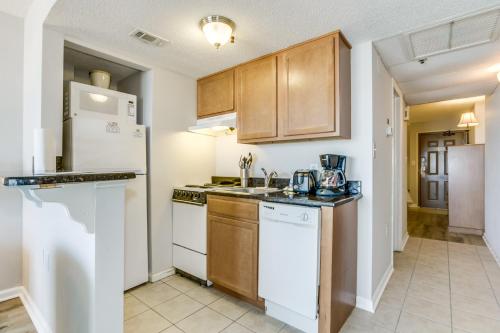 a kitchen with white appliances and wooden cabinets at Spectacular Oceanview Condos in Myrtle Beach