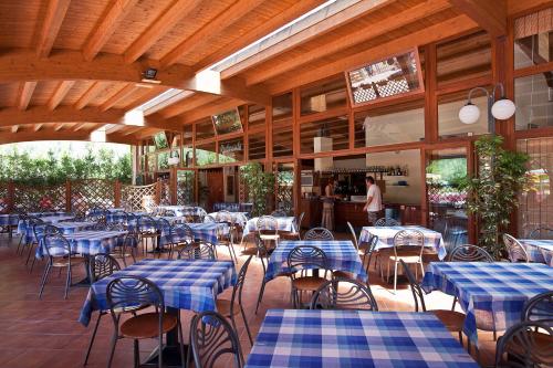 un restaurante vacío con mesas y sillas azules en Camping Village Free Time en Marina di Bibbona