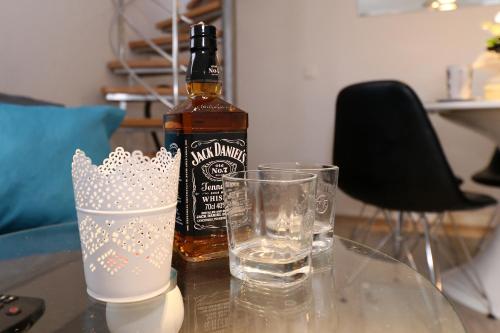 a bottle of alcohol sitting on a table with glasses at jm-Sutomišćica-holiday house on the beach in Sutomišćica