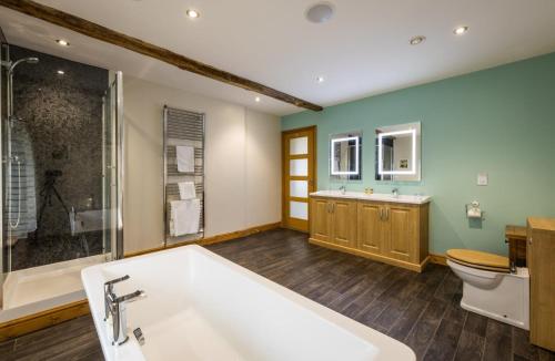 a bathroom with a tub and a toilet and a sink at The Inn at Ravenglass in Ravenglass