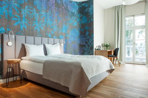 a bedroom with a bed with a blue floral wallpaper at Leśny Dwór in Sulęczyno