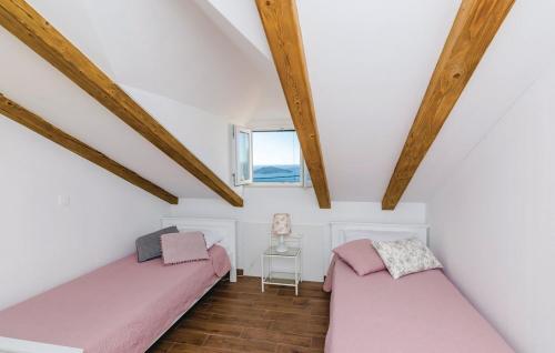 two beds in a room with wooden beams at Villa Maestral in Brsečine