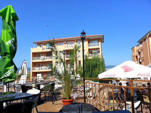 a restaurant with tables and umbrellas and a building at Sunny Day 6 - Menada Apartments in Sunny Beach