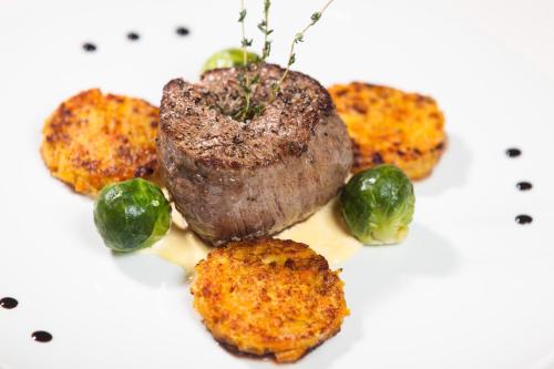 a piece of meat and vegetables on a white plate at Hotel-Restaurant Birkenhof in Bad Soden-Salmünster