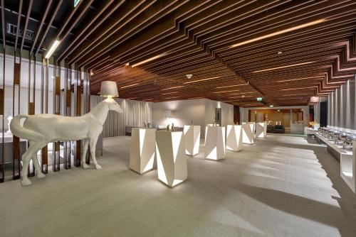 a room with a white sculpture of a deer and tables at The Act Hotel Sharjah in Sharjah