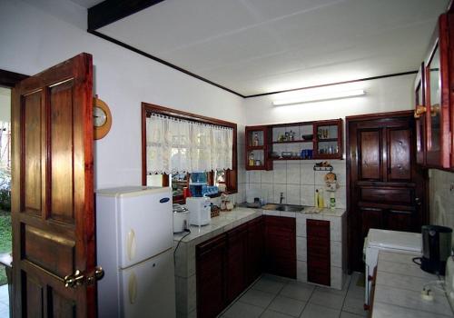a kitchen with a white refrigerator and a sink at La Rocaille in Baie Lazare Mahé