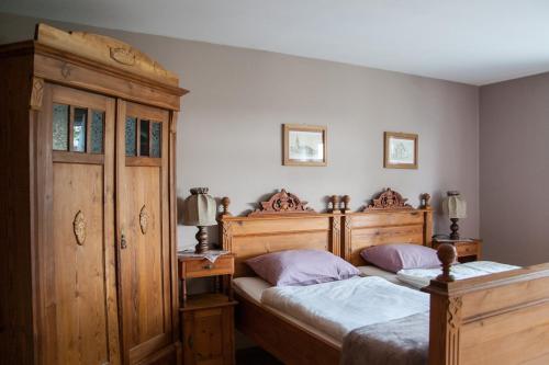 a bedroom with two beds and a wooden cabinet at Gościniec Pod Bukiem in Świeradów-Zdrój
