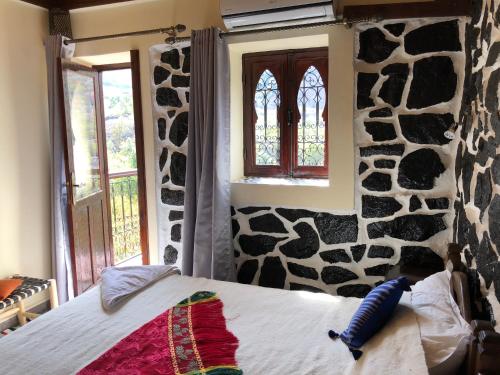 a bedroom with a bed with a fake rock wall at Riad Atlas 4 Seasons in Imlil