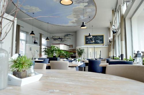 a restaurant with tables and chairs and a blue ceiling at Belgische Loodsensociëteit in Vlissingen