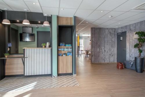 an office lobby with a reception desk and a table at B&B HOTEL Sainte-Maxime Golfe de Saint Tropez in Sainte-Maxime