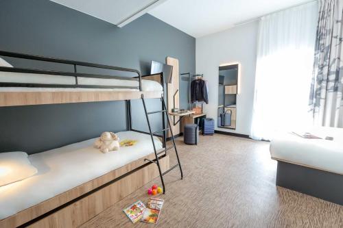 a bedroom with bunk beds with a teddy bear on the floor at B&B HOTEL Sainte-Maxime Golfe de Saint Tropez in Sainte-Maxime