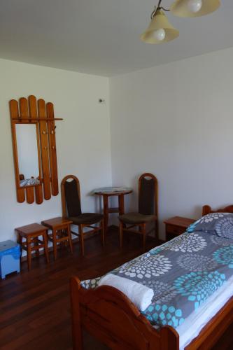 a bedroom with a bed and chairs and a mirror at Dom Pod Siódemką in Stronie Śląskie
