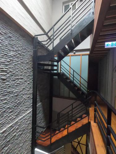 a spiral staircase in a building with a brick wall at Coral B&B in Xiaoliuqiu