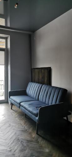 a large blue couch sitting in a room at Loft style apartments in the center in Sumy