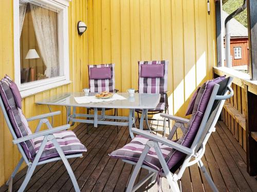 un tavolo e 4 sedie su un portico di 6 person holiday home in ULLARED a Ullared