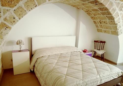 a bedroom with a bed and a brick wall at Sweet Home Arco Porta Luce in Galatina