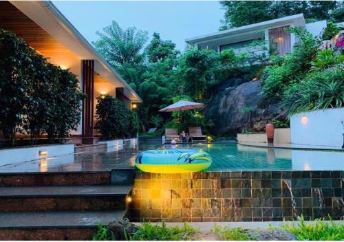 a swimming pool in the middle of a house at Le Candles Resort in Kozhikode