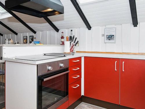 cocina con armarios rojos y blancos y fogones en 4 person holiday home in Esbjerg V, en Hjerting