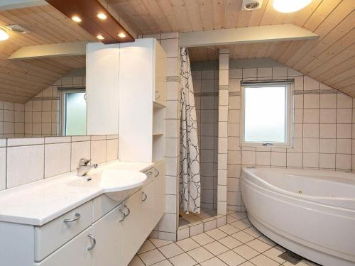 y baño con bañera, lavamanos y bañera tubermott. en 6 person holiday home in Ringk bing en Søndervig