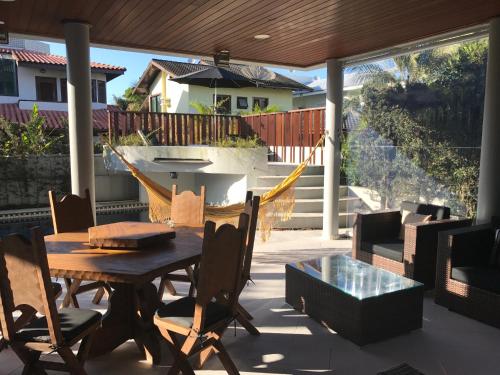 a patio with a table and chairs and a hammock at Hangaroa in Bertioga