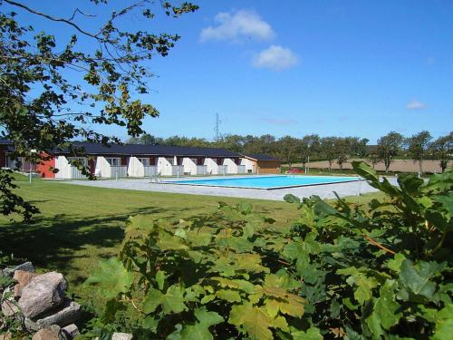 a swimming pool in the middle of a field at 4 person holiday home in Aakirkeby in Åkirkeby