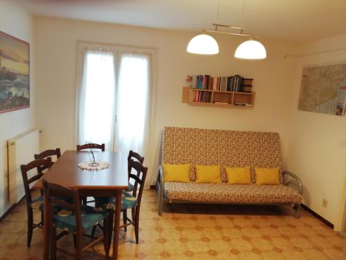 ein Esszimmer mit einem Tisch und einem Sofa in der Unterkunft Casa La Quiete in Orco Feglino