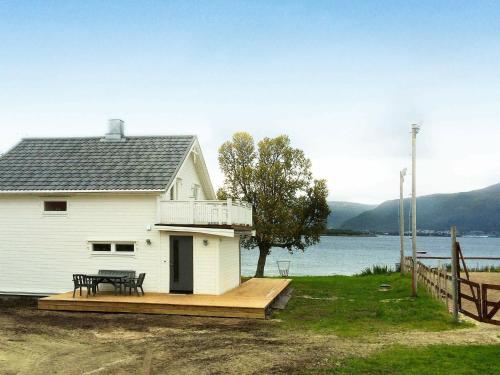 una casa blanca con una terraza junto a un cuerpo de agua en 8 person holiday home in KVAL YA, en Marisletta