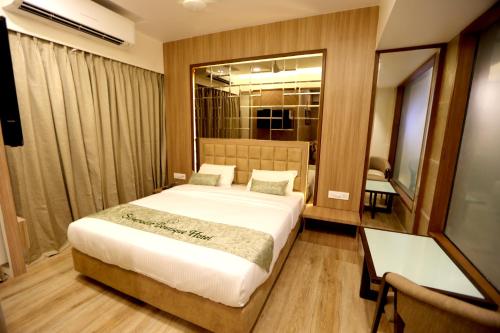a bedroom with a bed and a desk and a mirror at Silverador Boutique Hotel in Thane
