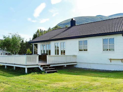 a white house with a porch and a yard at 6 person holiday home in tomrefjord in Fiksdal