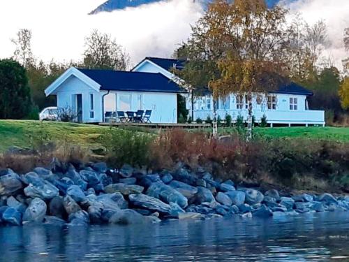 a flock of rocks in the water in front of a house at 6 person holiday home in tomrefjord in Fiksdal