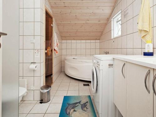 een badkamer met een wasmachine en een wastafel bij Holiday Home Diget in Dannemare
