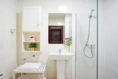 a white bathroom with a sink and a shower at Apartamento en centro ciudad con vistas al mar in Málaga
