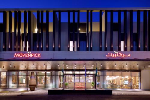 a nighttime view of a shopping mall with a large building at Mövenpick Hotel Tahlia Jeddah in Jeddah