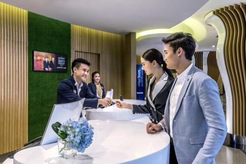 a group of people standing around a table at Novotel Bangkok on Siam Square in Bangkok
