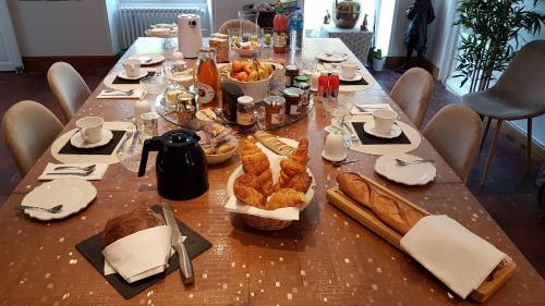 - une longue table avec du pain et de la nourriture dans l'établissement Chambre d'hôtes Liz'A, à Saint-Côme-de-Fresné