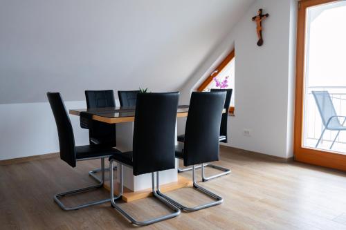 a room with a table with black chairs at PJagodic Apartments & Wellness in Cerklje na Gorenjskem