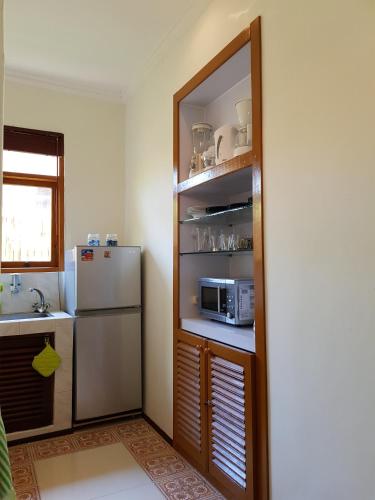 a kitchen with a refrigerator and a microwave at Dennis Holiday Bungalow in Jasri