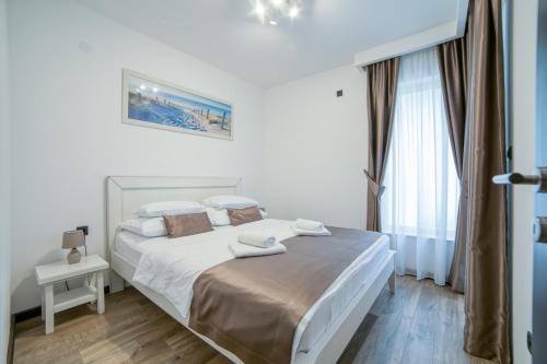 a white bedroom with a bed and a window at Casa Nuova in Kotor