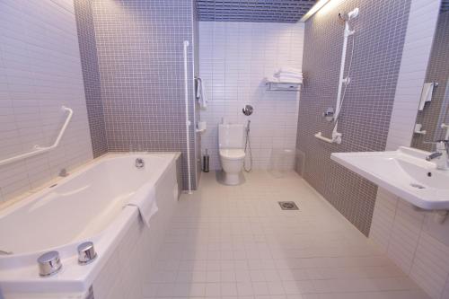 a bathroom with a tub and a toilet and a sink at Tallink Spa & Conference Hotel in Tallinn