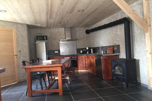 a kitchen with a wooden table and a stove at Chez Papy - Grand Appart Entirely renovated Ventelon La Grave La Meije in La Grave
