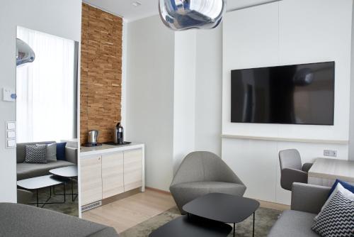 a living room with a couch and a tv on a wall at Tallink Spa & Conference Hotel in Tallinn