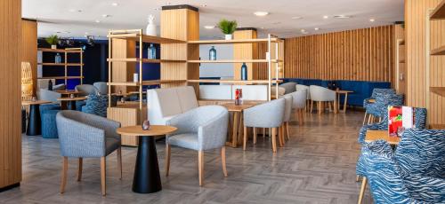 a restaurant with tables and chairs and shelves at Globales Don Pedro - Adults Only in Cala de Sant Vicent