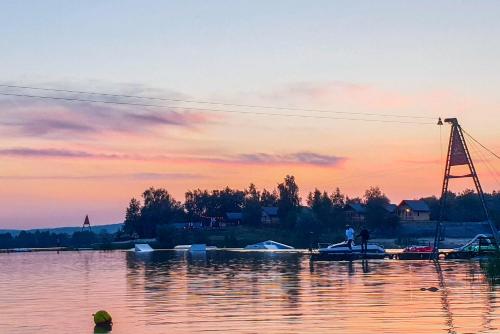 a sunset over a body of water with boats at Costa del Kryspi Całoroczne Domy na Wodzie in Cholerzyn
